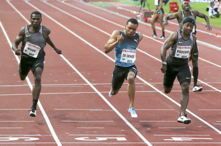 Canada's Andre De Grasse wins the 100m as 40-year-old Kim Collins, the early leader, pulls up ©Getty Images