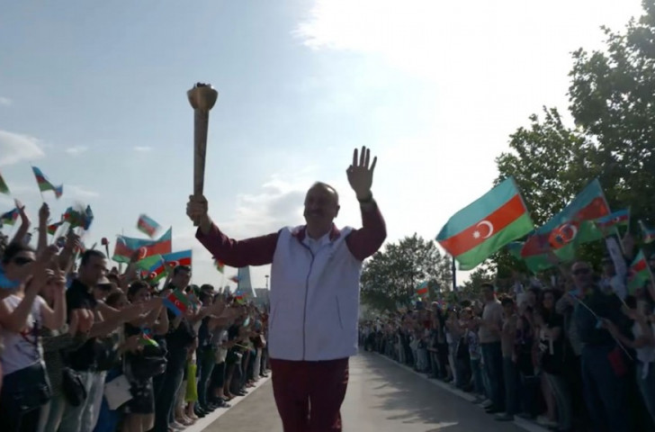 Azerbaijan's President Ilham Aliyev makes his way along the Baku Boulevard holding aloft the Torch