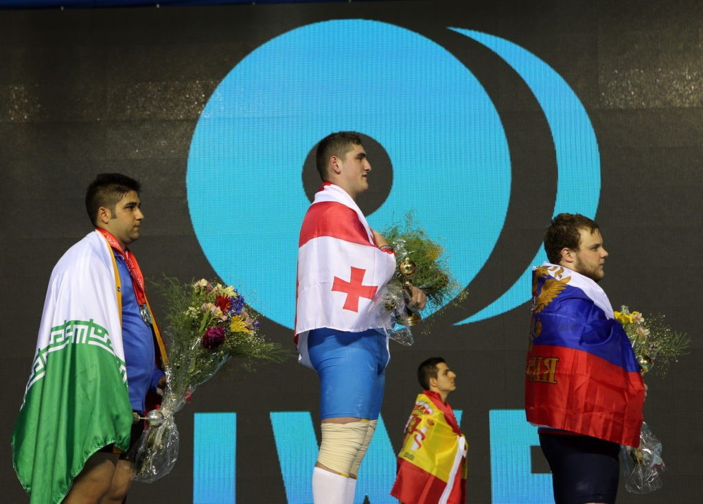 Georgia’s Giorgi Chkheidze (centre) delighted the home crowd on the penultimate day of action at the IWF Junior World Championships in Tbilisi, winning the men’s 105kg overall title ©IWF