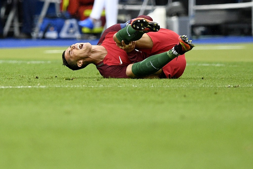 Cristiano Ronaldo lies on agony before departing from the field midway through the opening half ©Getty Images