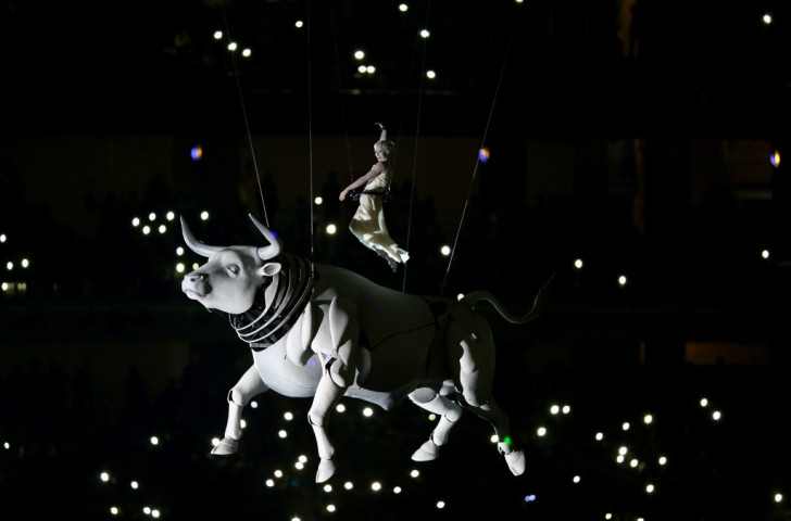 A performer depicting Europa, a Phoenician princess rides a white bull representing the greek god, Zeus ©Getty Images