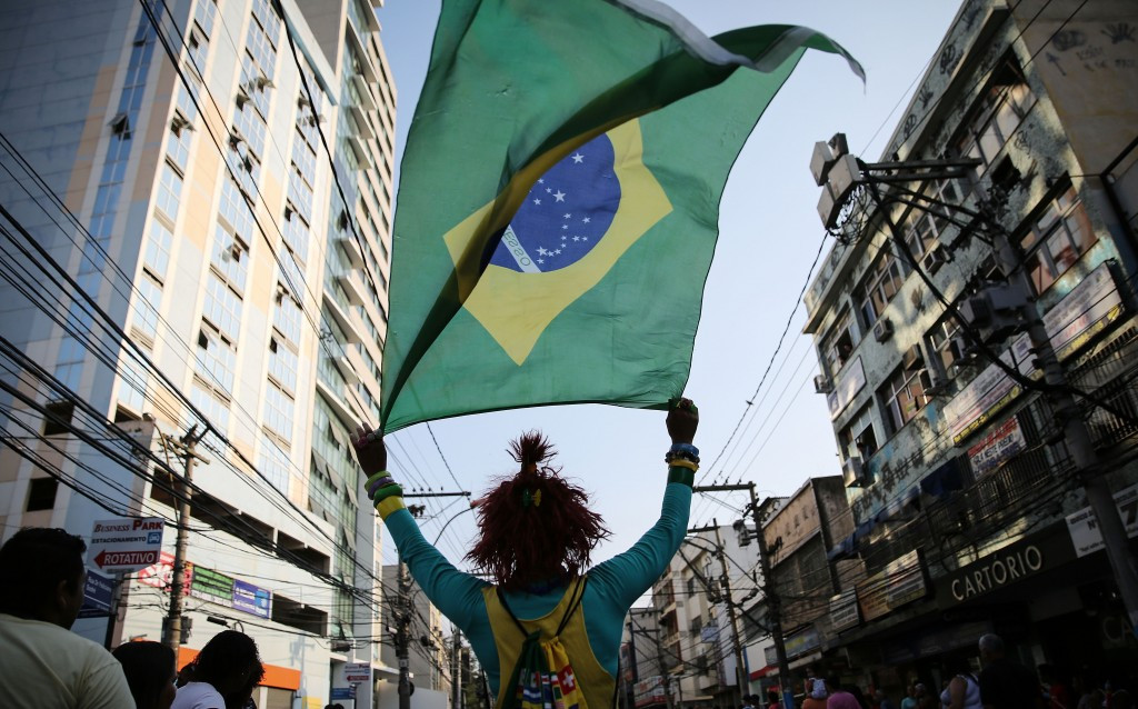 A Brazilian fan waves the national flag following the Olympic Torch's arrival in Sao Goncalo, Rio de Janeiro State ©Getty Images