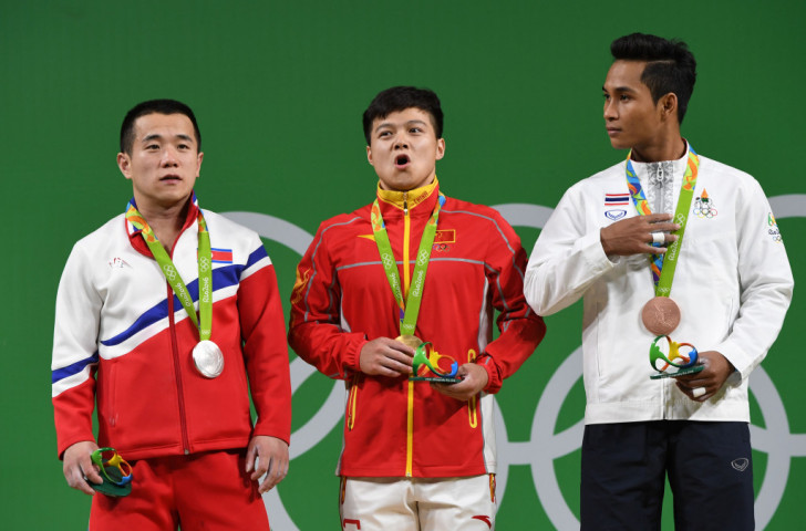 World record holder Long Qingquan celebrates 56kg weightlifting gold alongside London 2012 champion Om Yun Chol of North Korea, left, and bronze medallist Sinphet Kruaithhong of Thailand ©Getty Images