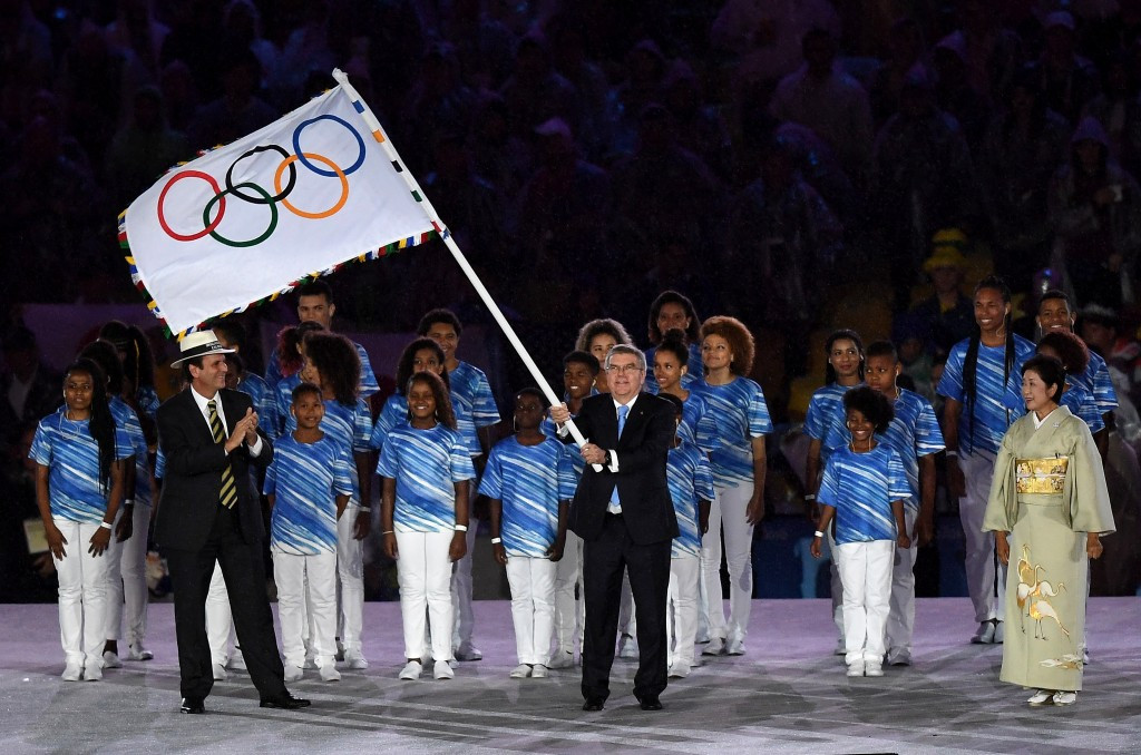 IOC President Thomas Bach holds the Olympic flag before it is passed from Rio de Janeiro to Tokyo ©Getty Images