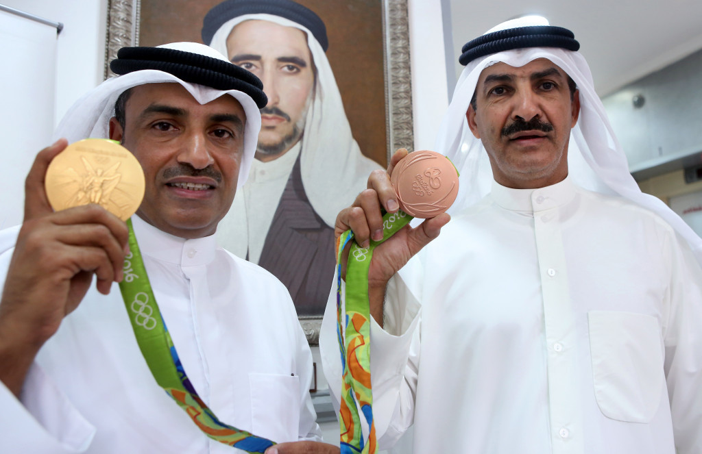 Shooter Fehaid al-Deehani (left) poses with his gold medal during a ceremony in Kuwait City, despite having won it as an independent athlete ©Getty Images