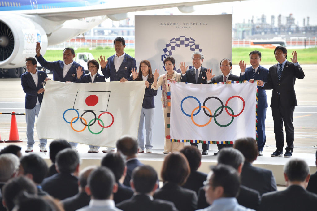 Tokyo Governor Yuriko Koike arrives with the Olympic flag alongside Japanese team members and officials ©Getty Images