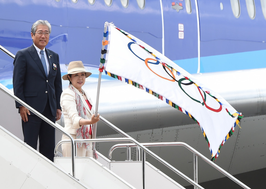 Tokyo Governor Yuriko Koike waves the Olympic flag beside JOC President Tsunekazu Takeda ©Getty Images