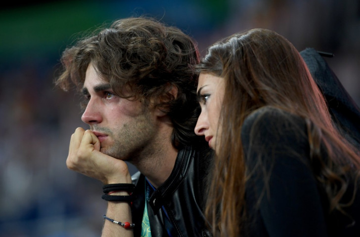 Gianmarco Tamberi of Italy, who injured himself on the eve of the Games after a year in which he has taken the world indoor and European titles, watches the Rio 2016 high jump with his girlfriend at his side ©Getty Images