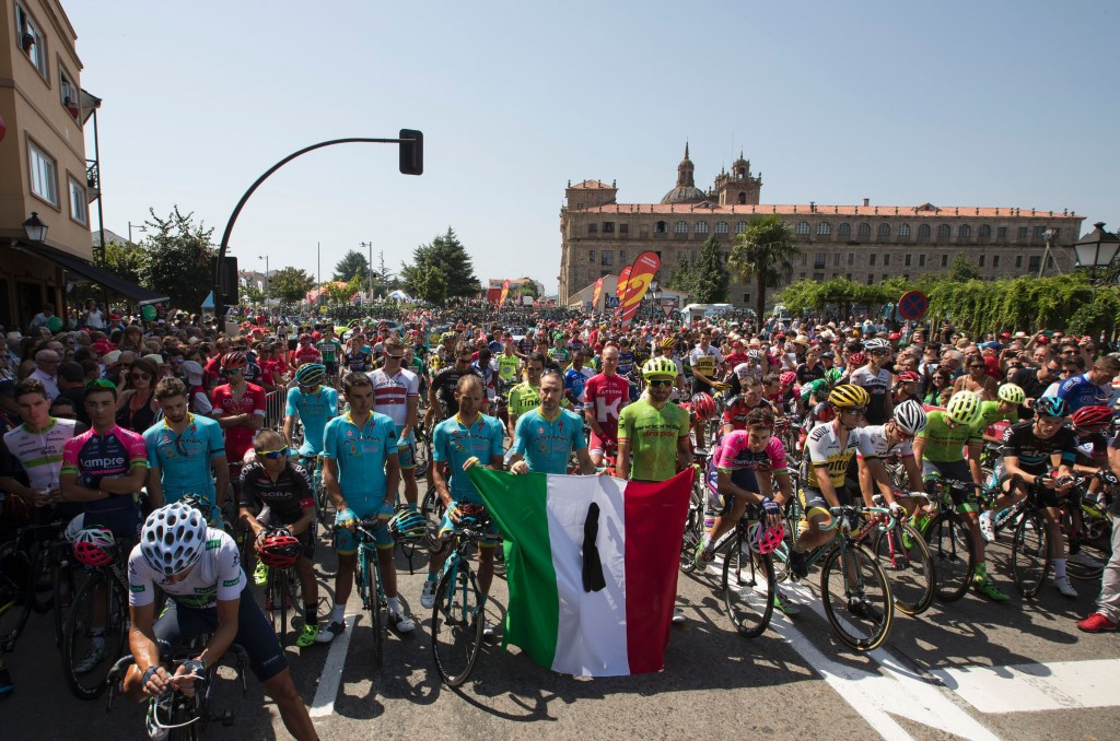 Cyclists held an Italian national flag bearing a black ribbon in tribute to the victims of yesterday's earthquake ©Getty Images