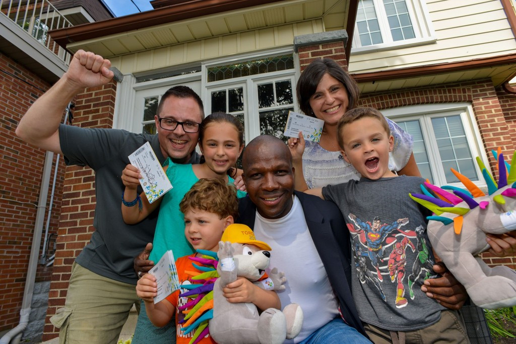 The Vanderspek family from Toronto were surprised by Donovan Bailey and mascot Pachi ©CNW Group/Toronto 2015