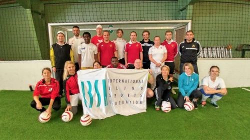 Players and coaches pose with the IBSA flag after a session ©IBSA