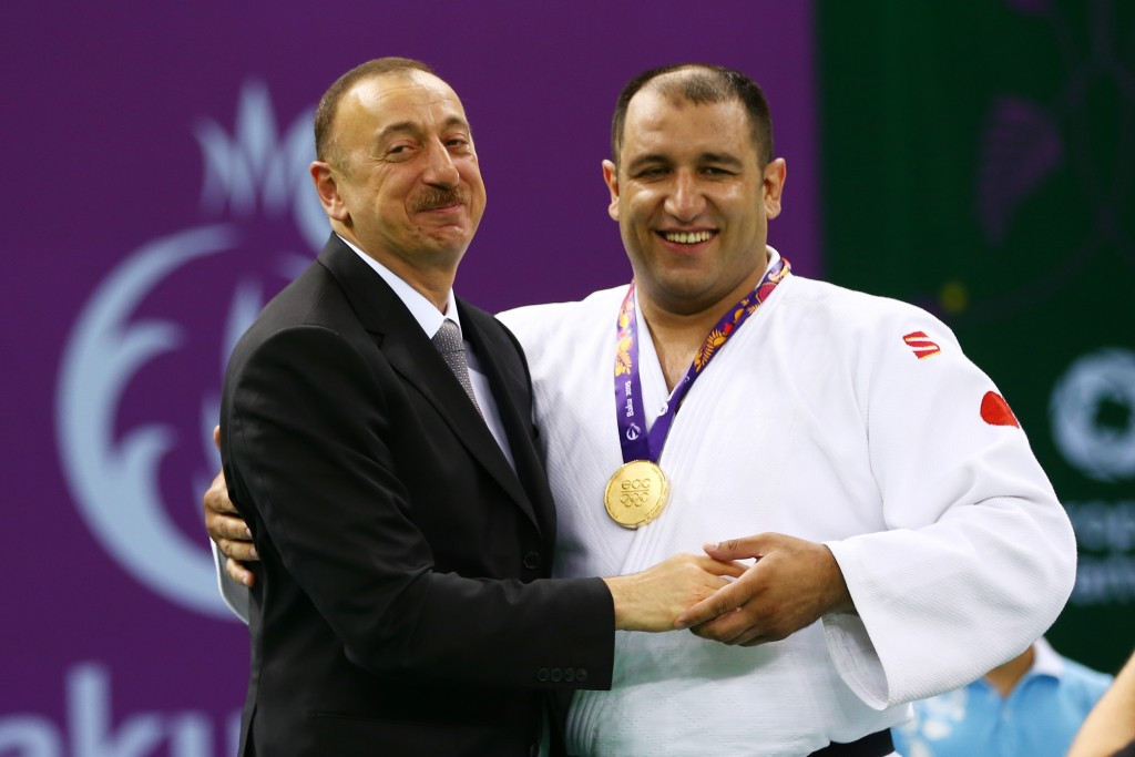 Azerbaijan's President  Ilham Aliyev briefly joined judoka Ilham Zakiyev on top of the podium after presenting him his gold medal