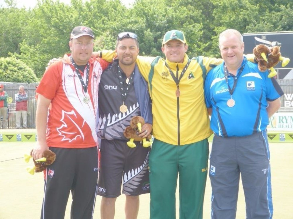 New Zealand's Shannon McIlroy (second left) triumphed in the men's singles event ©World Bowls