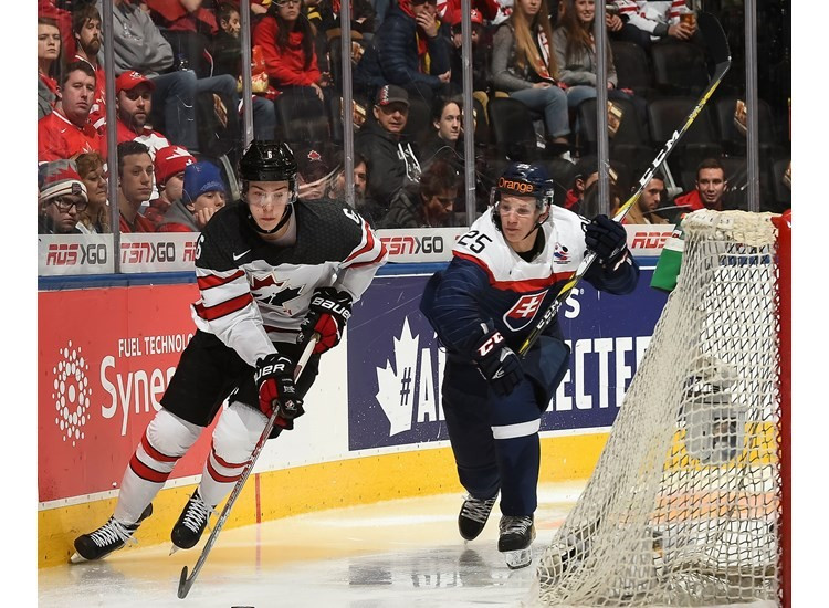 Canada's Philippe Myers (left) carries the puck while Slovakia's Milos Roman (right) follows closely behind ©IIHF
