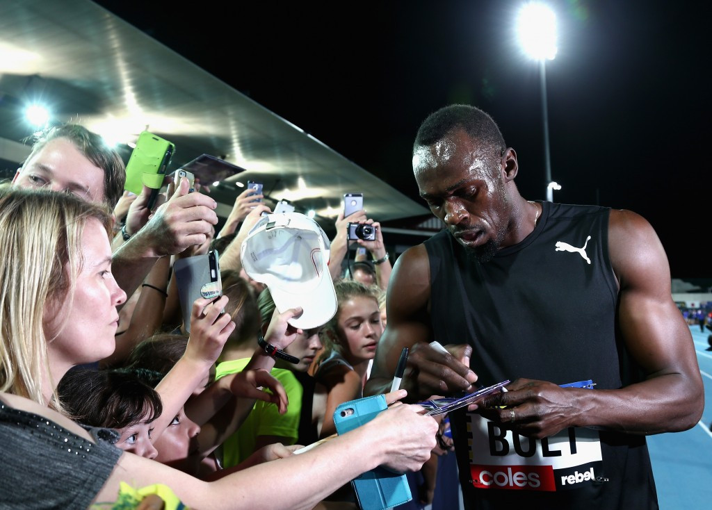Usain Bolt signs autographs for fans after his intervention with the judges had ensured a second win for his All-Stars in the Nitro Athletics Series ©Getty Images
