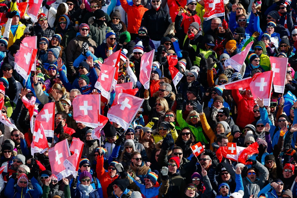 Swiss supporters raise national flags in celebration during the downhill finals ©Getty Images