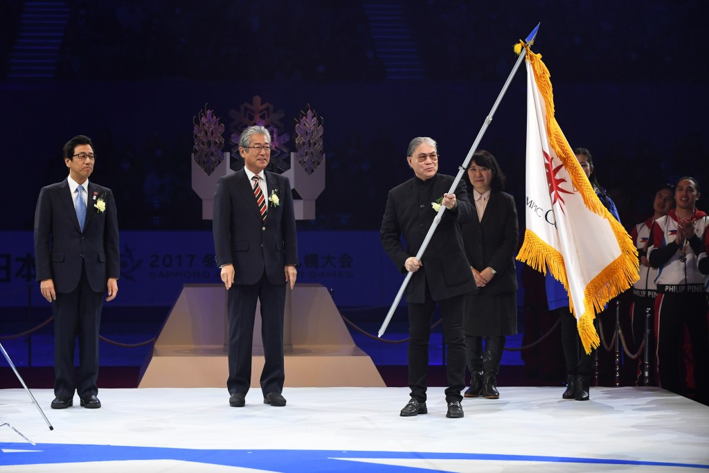 Timothy Fok, right, receives the OCA flag to mark the formal end of Sapporo 2017 ©Getty Images