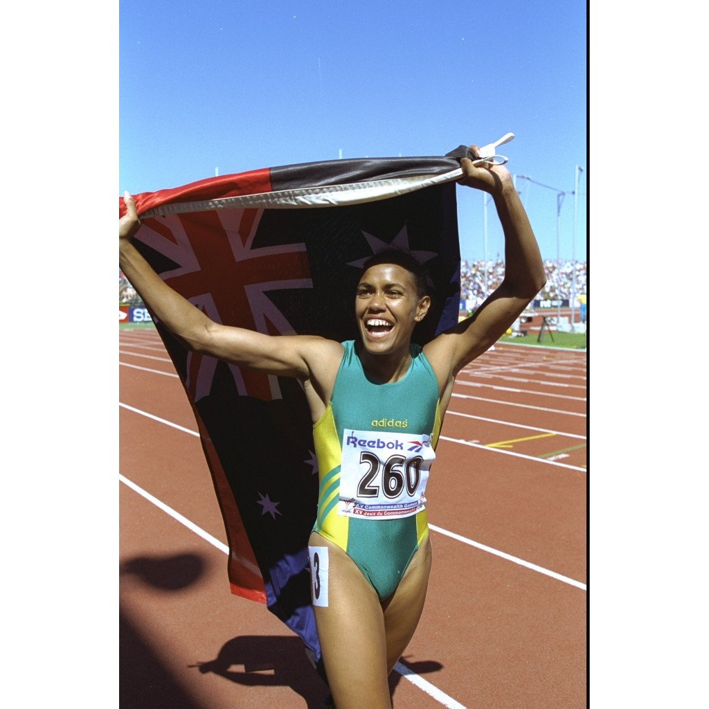 Cathy Freeman celebrates her 400 metre win at the 1994 Commonwealth Games with the Australian and Aboriginal flags ©Getty Images