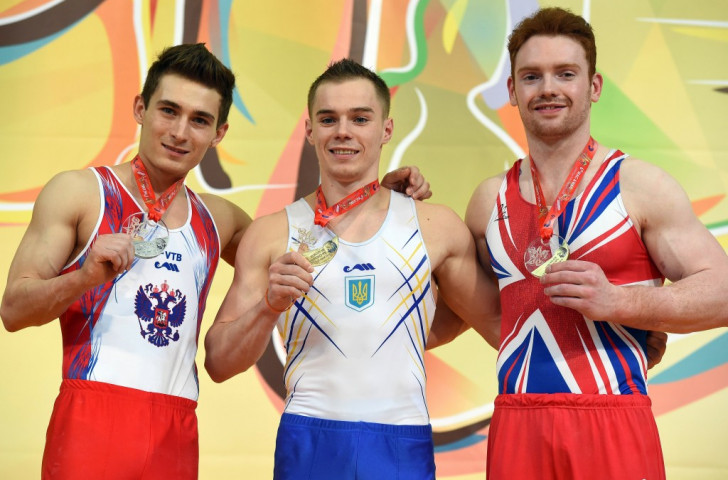 Men's all-around gold medallist Oleg Verniaiev (centre) with silver medallist David Belyavskiy (left) and bronze medallist Dan Purvis (right)