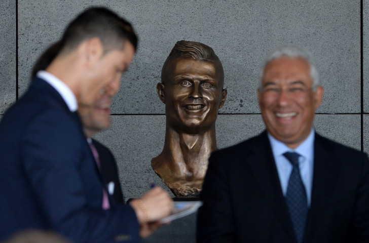 Cristiano Ronaldo, pictured at the ceremony re-naming Madeira Airport after him, appears to be taking in good heart the appearance of a bronze bust depicting Niall Quinn ©Getty Images