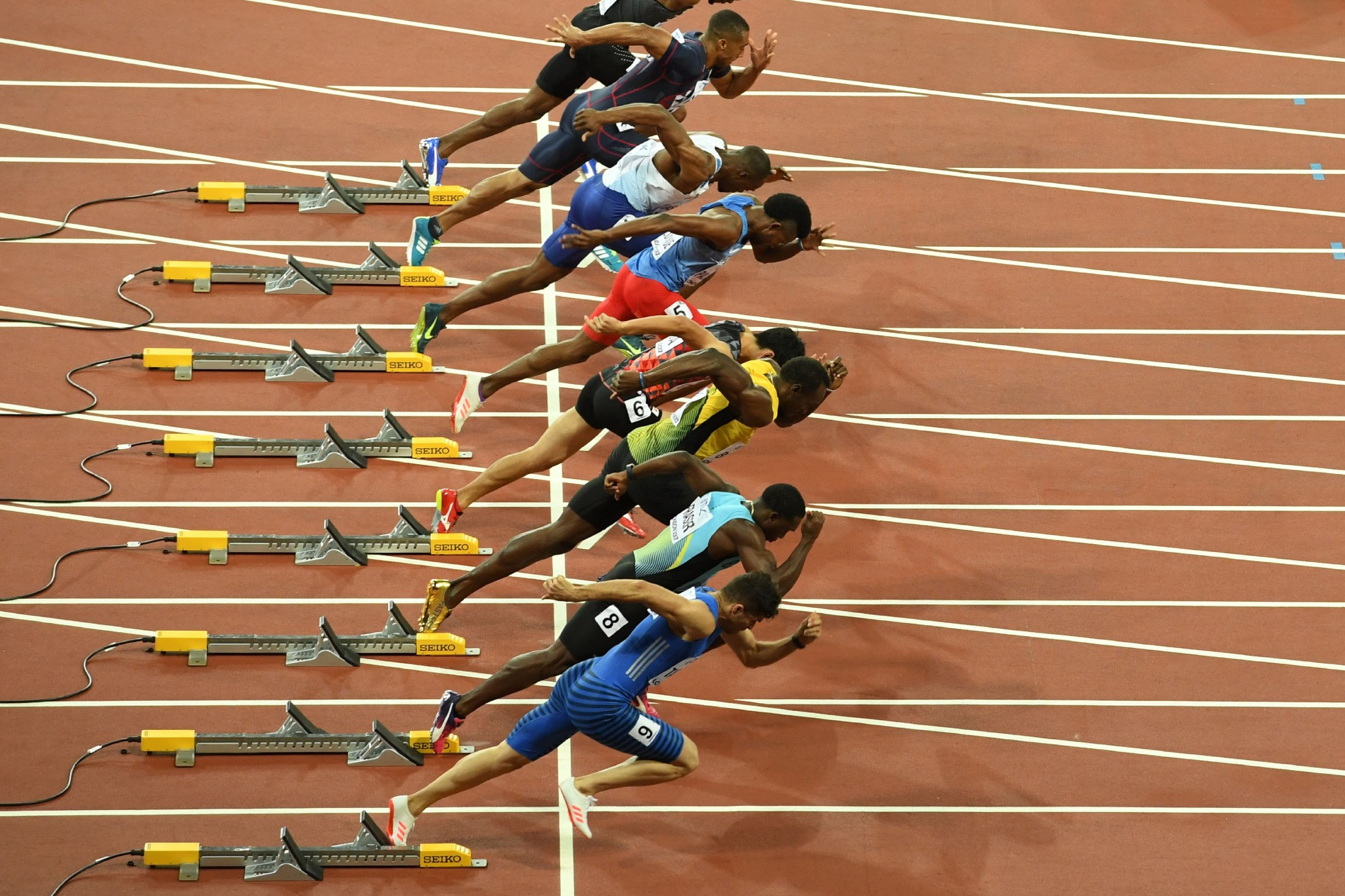 Athletes power out of the blocks in the men's 100m heats ©Getty Images