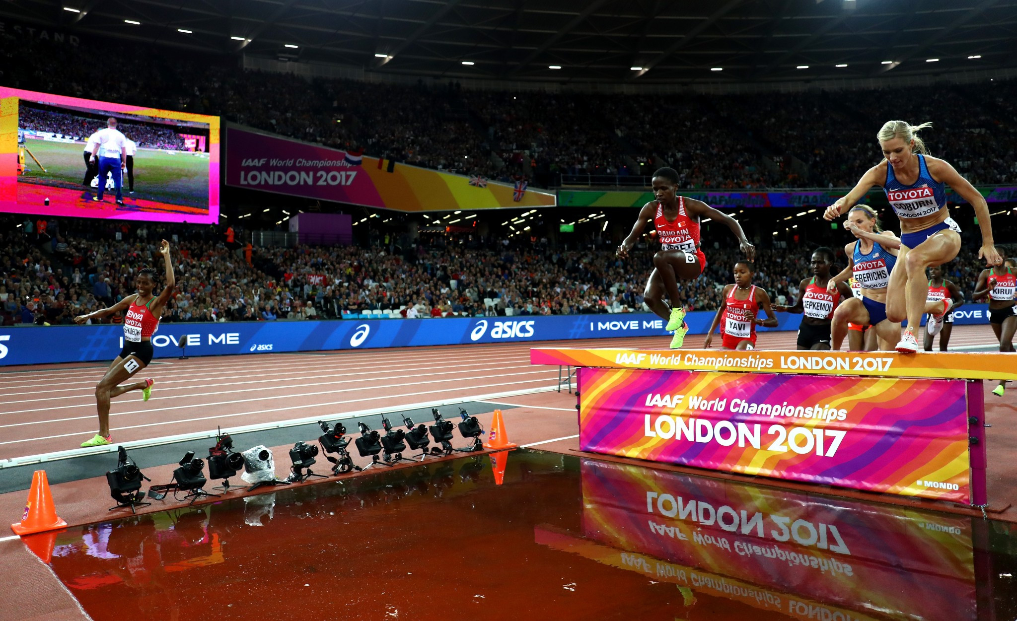 Athletes clear the water jump in the steeplechase final, except for Kenya's Beatrice Chepkoech, left, who had to double back after running past it ©Getty Images