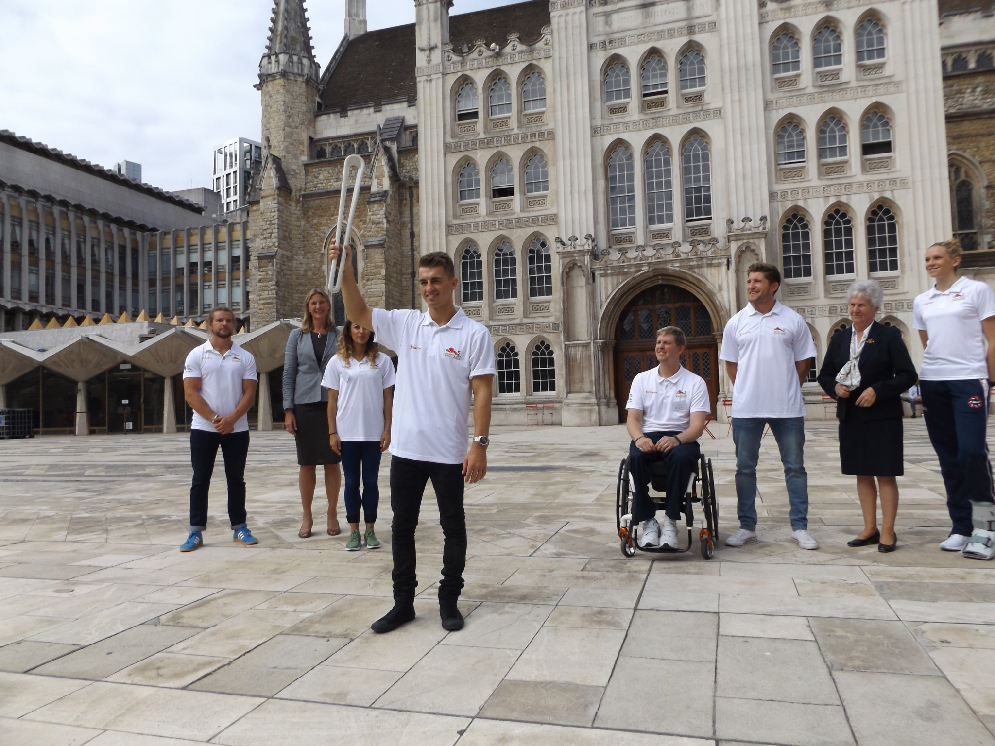 Max Whitlock holds up the Queen's Baton outside Guildhall in London ©Philip Barker