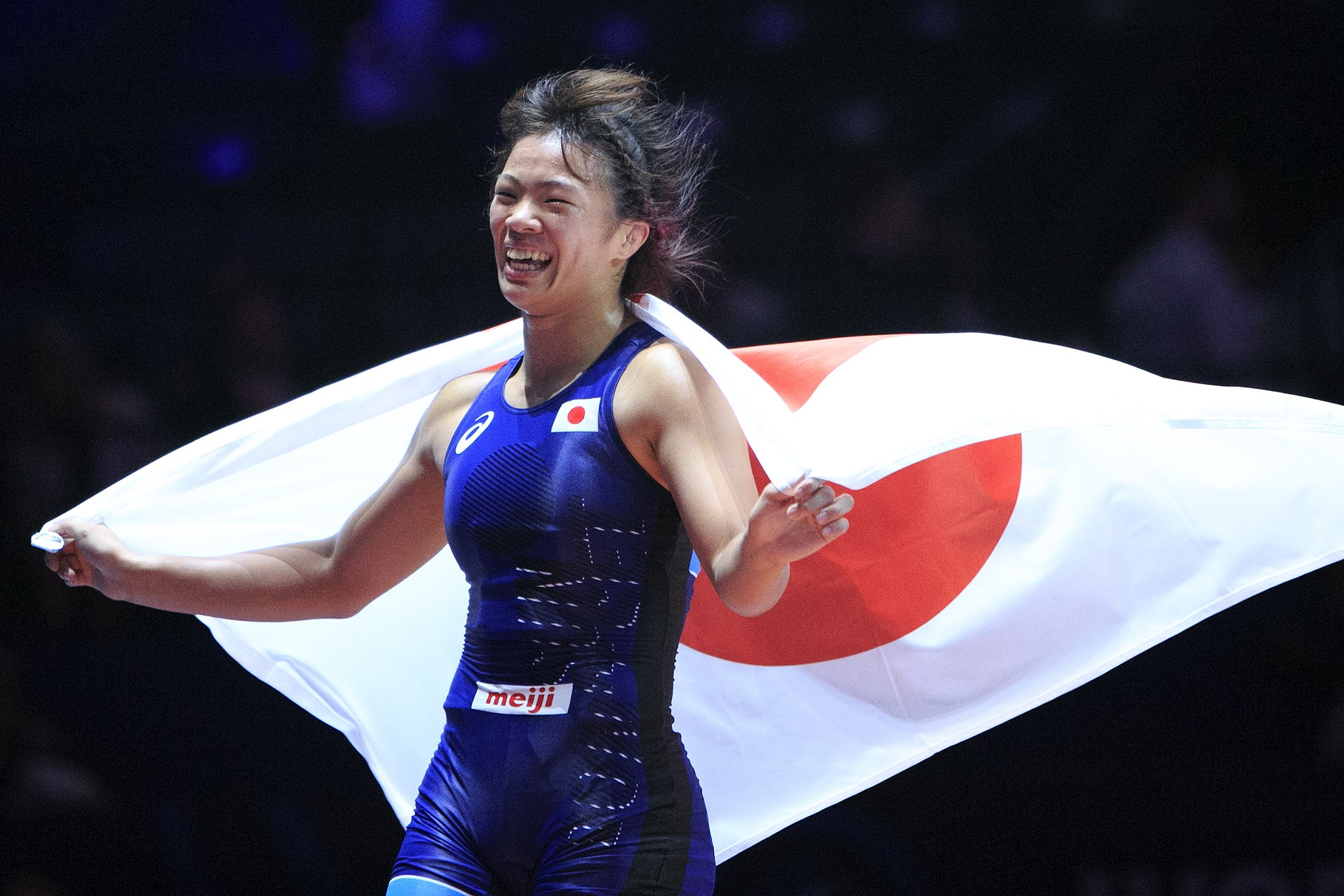 Kawai celebrated by running around the mat draped in a Japanese flag ©UWW