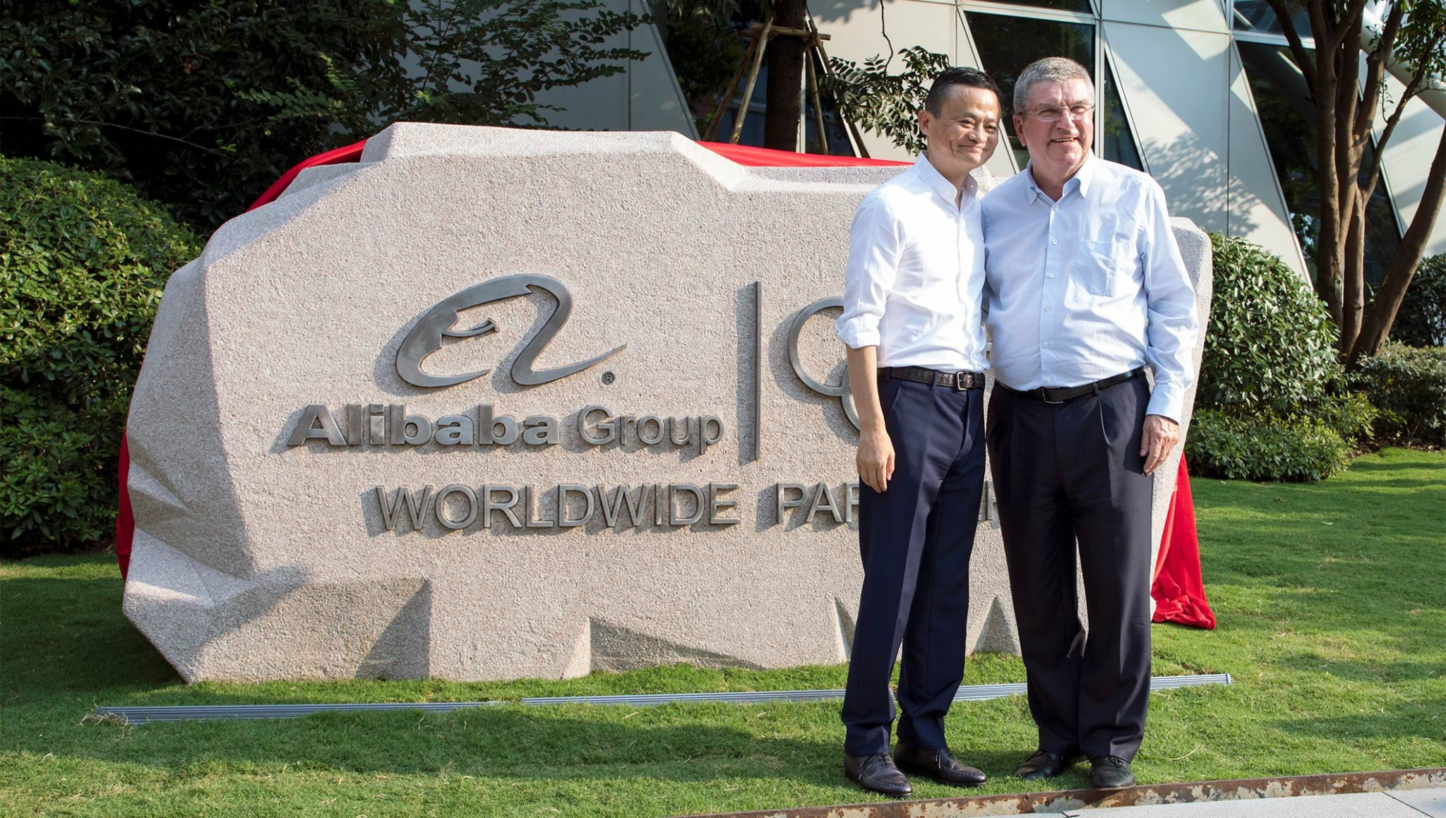 Alibaba chairman unveils new logo on plaque after meeting IOC President Bach