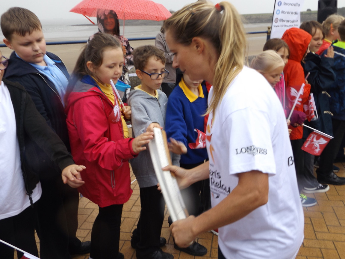 Olympic gold medallist Hannah Mills showing the baton to local children ©Philip Barker