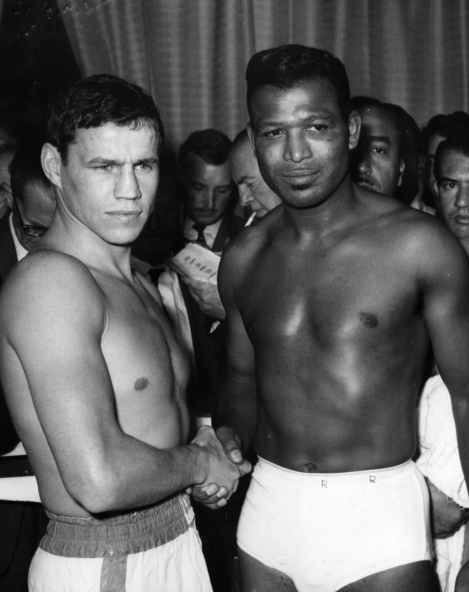 British boxer Terry Downes, left, and Sugar Ray Robinson, the former world middleweight champion, shaking hands at the weigh-in before their fight at Wembley, London ©Getty Images