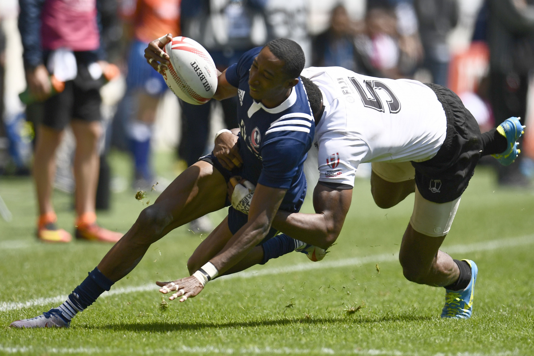 The United States' Perry Baker, left, seen here trying to escape the clutches of Fiji's Sevuloni Mocenacagi in Paris in May, is on the World Sevens shortlist ©Getty Images