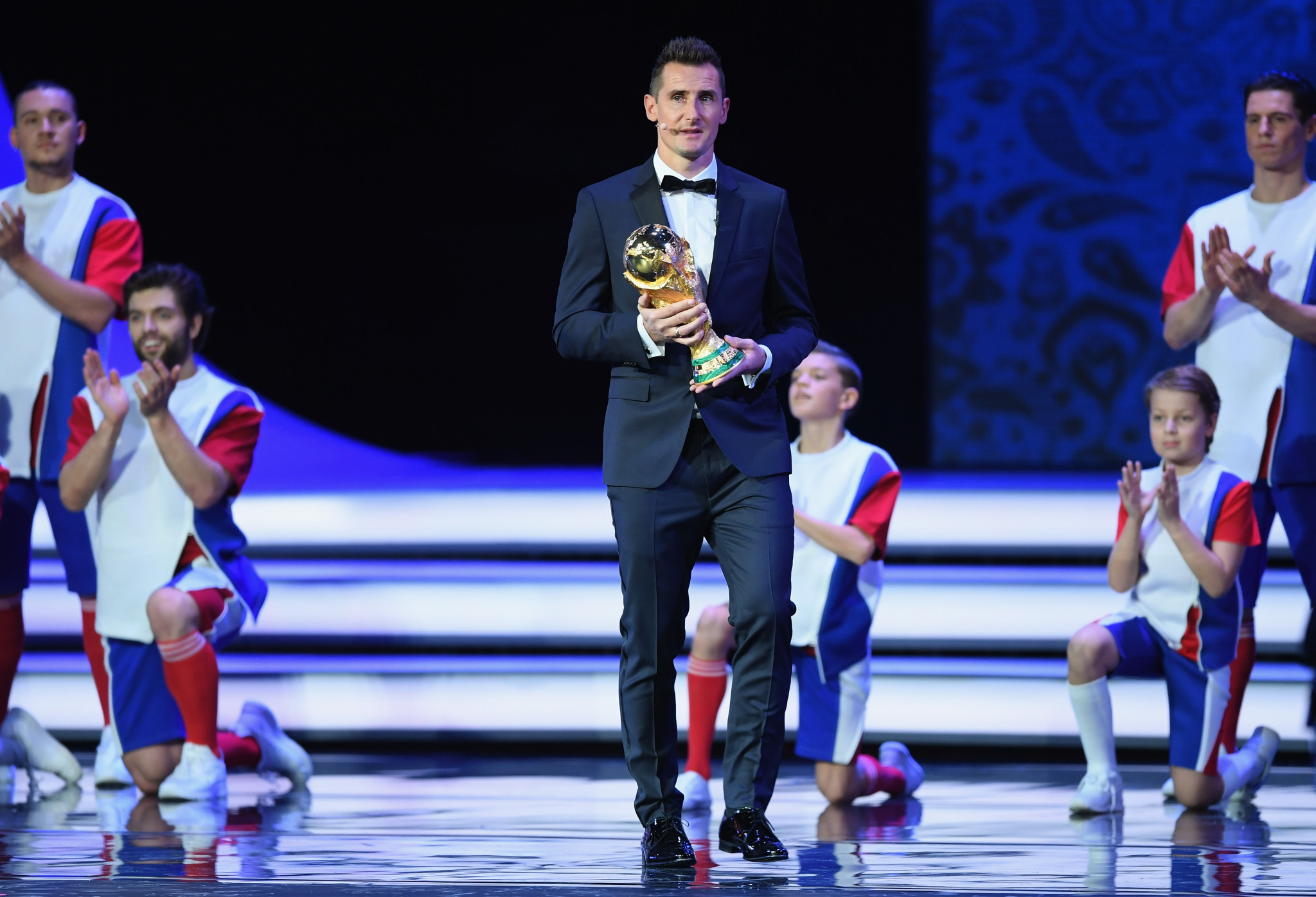 Former Germany striker Miroslav Klose carried the World Cup trophy onto the stage ©Getty Images