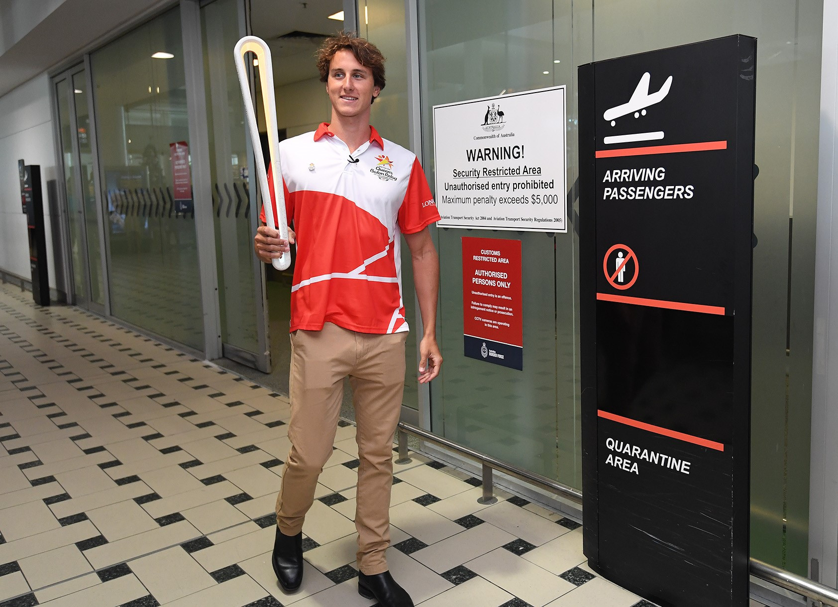 Gold Coast 2018 ambassador Cameron McEvoy carried the Queen's Baton through arrivals at Brisbane International Airport ©Gold Coast 2018