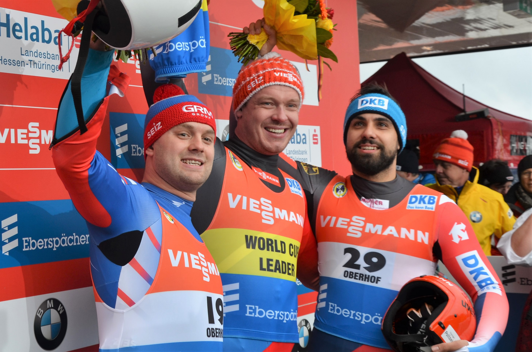 Germany's Felix Loch, centre, has increased his lead in the FIL World Cup standings after winning the men’s singles event in front of a home crowd in Oberhof today ©FIL