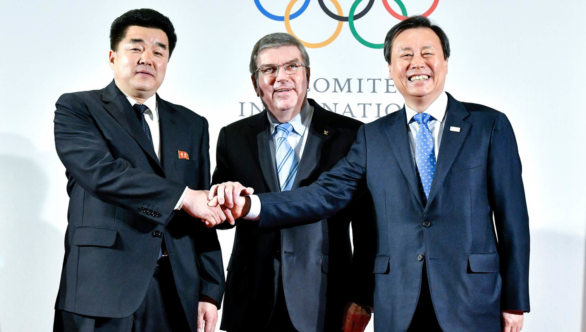 IOC President Thomas Bach, centre, alongside representatives from North and South Korea ©IOC