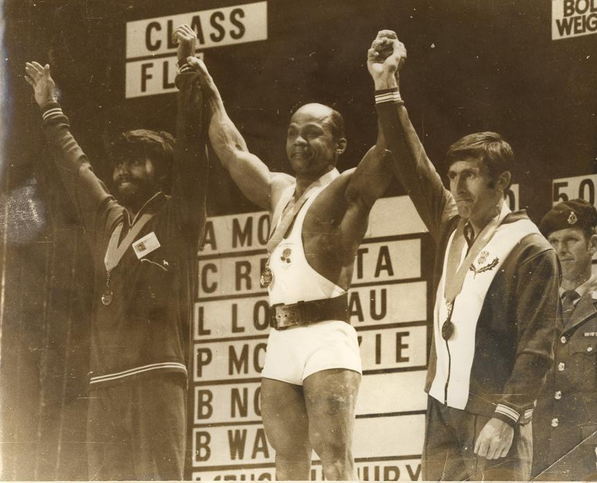 Precious McKenzie celebrates winning his third consecutive Commonwealth Games gold medal at Christchurch 1974, a performance watched by the Queen and Duke of Edinburgh ©Getty Images