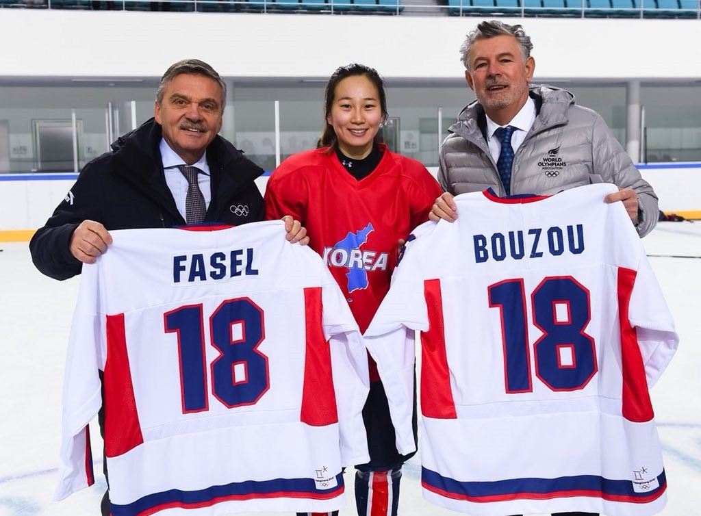Peace and Sport President Joël Bouzou, right, and IIHF counterpart René Fasel, left, asked the joint Korean women's ice hockey team to pose for the #WhiteCard photo ©Peace and Sport