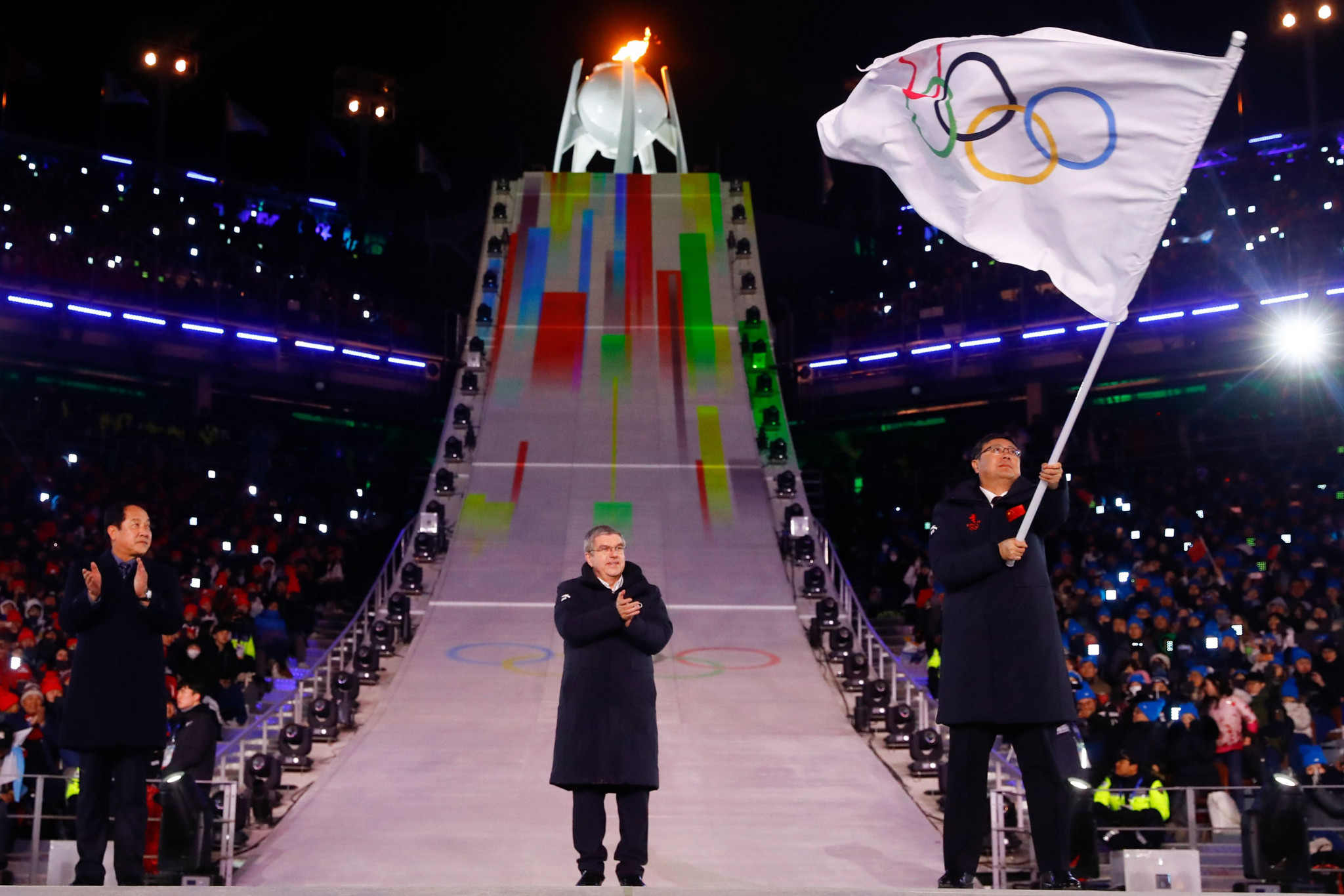 Beijing Mayor Chen Jining waves the Olympic flag during the Pyeongchang 2018 Closing Ceremony to mark the fact the Chinese city will host the 2022 Olympics as IOC President Thomas Bach watches on ©Getty Images
